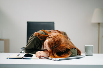 Young Asian woman in office showing signs of stress and burnout while working on laptop. Concept of...