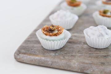 Assorted White Chocolate and Nut Truffles mini dessert bites on Marble Board side view Sweet Dessert Treats Display