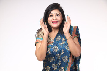 Excited Indian woman wearing traditional colorful saree with arms open gesture and facial mouth...
