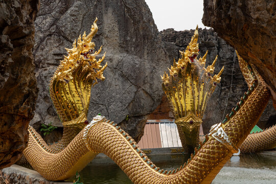 Golden Naga statues spraying water at Wat Phu Taphao Thong, photographed on April 13, 2023 in Udon Thani, Thailand