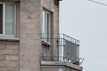 Dilapidated Building Balcony Exterior: Gray Stone Facade, Rusty Metal Railing, Urban Decay,...