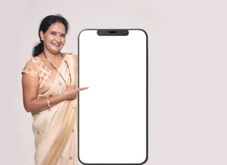 Indian happy women showing mobile Screen.. looking in front of the camera. wearing traditional...