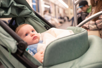  baby boy in green stroller in subway car
