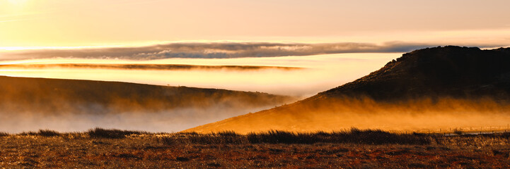Panorama of a firey morning glow over low lying mist, cloud inversion, by Higger Tor, Hathersage, Peak District, UK