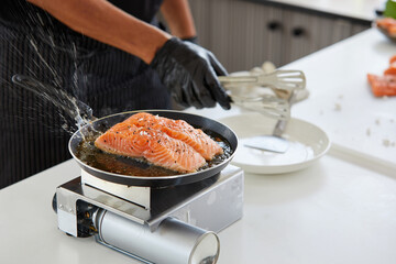 chef cooking salmon steaks in the kitchen