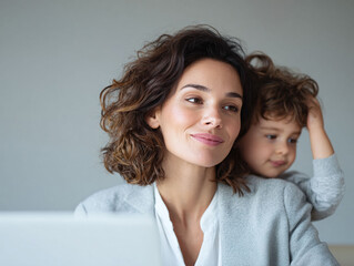 Working mom A smiling woman in business attire embraces her child. Represents worklife balance, family, juggling responsibilities. Ideal for articles, ads.