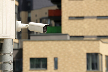 Surveillance camera on city street, modern security technology, big brother concept, urban safety, CCTV monitoring