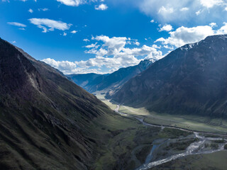 Scenic view of Chulyshman River Valley in Altai. lush green vegetation and towering mountains under cloudy sky. Travel and landscape photography.