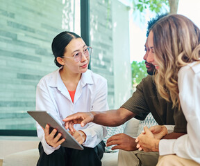 Young couple listening their financial advisor  or a real estate agent who is using tablet during a...