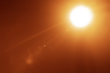 glowing light on blue background, shining effect element. Shining sun at clear blue sky with empty copy space. Sunny summer days with blue heaven. Sunrays, sunbeams, sunburst, sunlight.