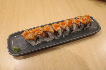 Spicy Tuna Sushi Roll Topped with Sauce and Tobiko Roe