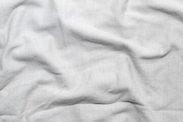 A wrinkled white t-shirt texture, displaying soft folds and shadows.