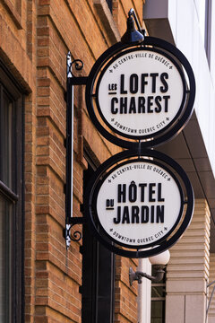 Quebec City, Quebec, Canada, June 21, 2025 - Vertical low angle view of the Lofts Charest and the H&ocirc;tel du Jardin round black and white signs in lower downtown