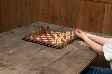 Woman is moving chess pieces on chess board	