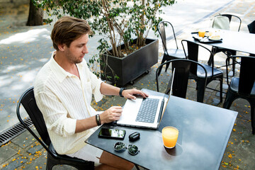 Digital nomad lifestyle scene 
Young man working on laptop