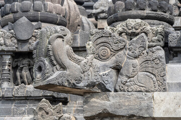 Closeup view of ancient stone gargoyle in shape of makara head, Shiva hindu temple, Prambanan, Yogyakarta, Central Java, Indonesia