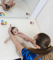 Torticollis in infants. Physiotherapist performs examination to diagnose wryneck in child, performs...