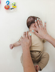 Torticollis in infants. Physiotherapist performs examination to diagnose wryneck in child, performs...