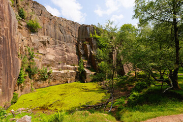 Along the gritstone rock face in the disused Bole Hill Quarry, Hope, Derbyshire.