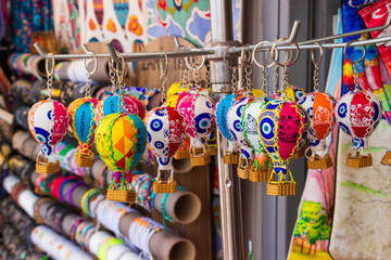 Close-up of many small colorful toy balloons leather is a souvenirs for tourists on street market. Hot air balloon is a popular gifts from Uchisar in Cappadocia, Turkey. Selective focus