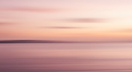 Obraz premium Abstract blurred landscape with soft pink and orange hues and a dark horizontal line at the horizon