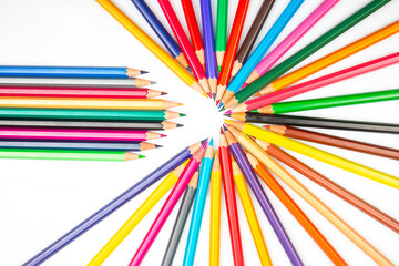 A vibrant arrangement of colored pencils in a circular pattern with some pencils extending outward...