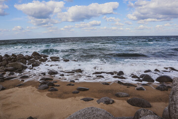 Rocky Seashore with Ocean Waves under Blue Sky