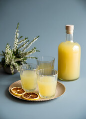 A refreshing summer drink and a bottle with a floral arrangement.