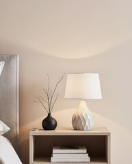 Minimalist Bedroom Nightstand with Elegant Table Lamp, Black Vase, and Books Against Neutral Wall