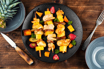 Chicken meat with pineapple on skewers.