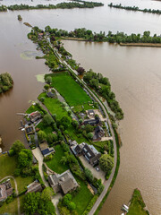Aerial view of a scenic lakeside village with narrow peninsulas, green fields, and houses...