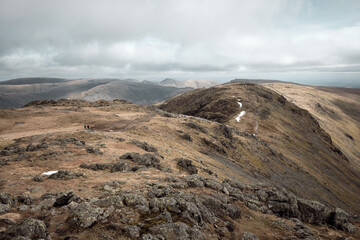 Hikers descending from Hart Crag to Dove Crag on the Fairfield Horseshoe, Lake District, UK