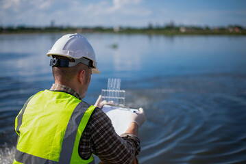 An environmental expert is examining the aquatic life in a treatment pond.