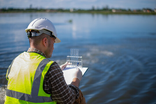 A specialist engineer at a treatment pond is checking the water quality of the treated pond.