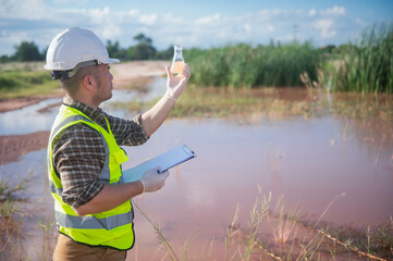 An environmental expert is collecting water samples from a natural pond to test the ecosystem for health.