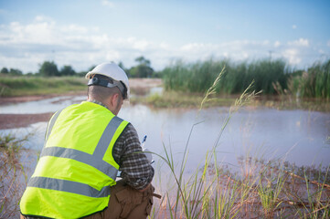 An environmental expert is collecting water samples from a natural pond to test the ecosystem for health.