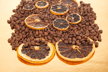 Warm-toned coffee beans and dried orange slices on a reflective golden backdrop, ideal for food and beverage photography. coffee aroma and taste citrus descriptors