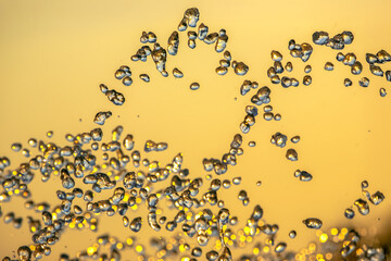 silhouettes of drops falling water fountain against the backdrop of the setting sun