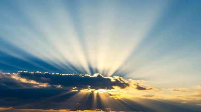 Sunlight casting rays through clouds in a blue sky at sunset  