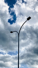 Tall lamp post under a partly cloudy sky