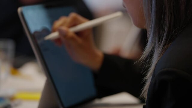 Close Shot of Hand Taking Notes on Tablet During Office Meeting