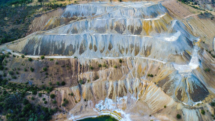 Aerial view of Tsar Asen Mine, Bulgaria – colorful terraced slopes of a former open-pit mine where non-ferrous metals, especially copper, were once extracted. Nature slowly reclaims the site.