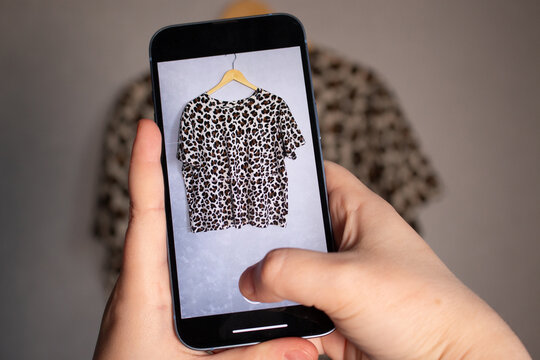 Woman taking photo of her old clothes for resale. Second hand concept. Closet organization.