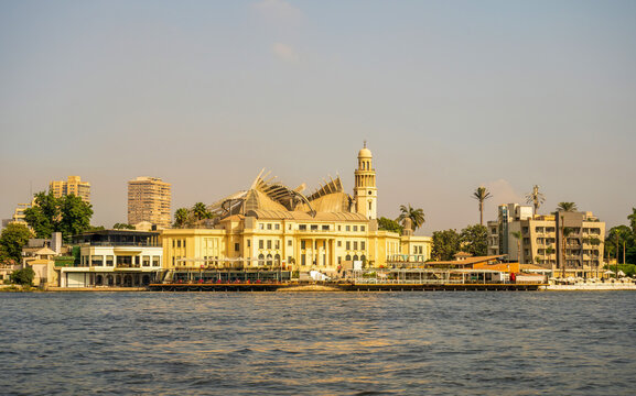 Glimpse of Zamalek's elegant architecture from the Nile, featuring a prominent building with a distinctive dome and tower in Cairo, Egypt.