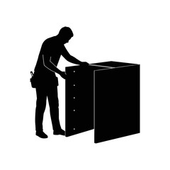Man assembling furniture while standing beside a cabinet in workshop  