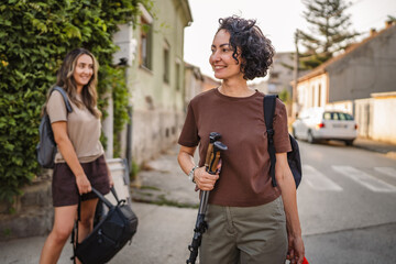 mature woman wait for transport hold hiking poles and backpack