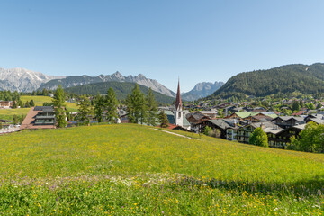 31 may 2025, Seefeld, Austria. View on Seefeld in Tirol village with church and houses. Mountains...
