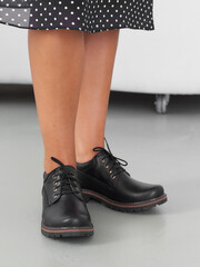 Stylish black boots paired with a polka dot skirt in a modern indoor setting