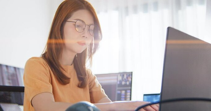 Asian female freelance programming developer work alone using desktop and laptop computer at home office. Information technology, smart woman, software engineer programmer coding job. Copy space