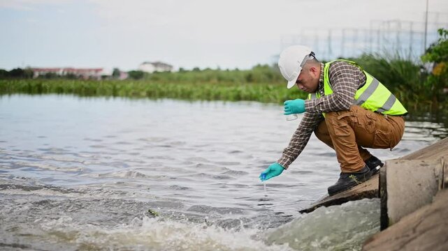 A specialist engineer at a treatment pond is checking the water quality of the treated pond.